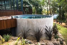 an outdoor hot tub surrounded by plants and rocks