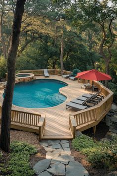 an above ground pool with decking and umbrellas next to it in the woods