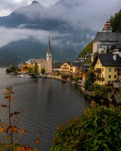 a town on the edge of a body of water with mountains in the background