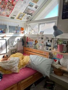 a small bedroom with a bed and lots of clutter on the wall above it