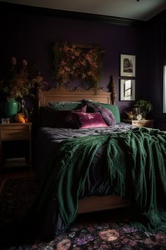 a bed with green blankets and pillows in a dark room next to a large window