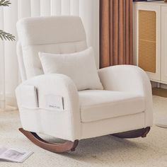 a white rocking chair sitting in a living room