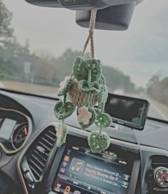 the interior of a car is decorated with green crocheted decorations and hanging from a rope