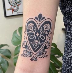 a woman's arm with a heart tattoo on it