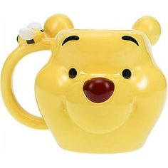 a yellow winnie the pooh mug with a red nose