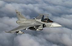 a fighter jet flying through the sky above some clouds