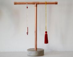 a wooden stand with two long red tassels hanging from it's sides