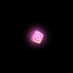 the instagram logo is lit up in the dark with pink light on it's side