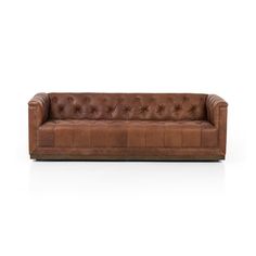 a brown leather couch with buttons on the back and arms, sitting against a white background