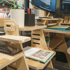 a wooden desk with books and magazines on it in front of a computer monitor screen