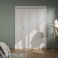 a bedroom with green walls and white closets next to a bed in the corner