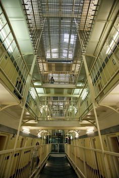 the inside of a jail cell building with stairs and railings leading up to the second floor