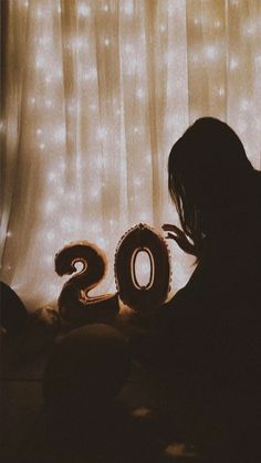 a person sitting in front of a curtain with the number 20 on it