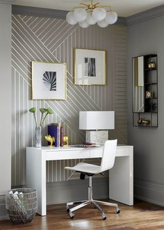 a white desk with a computer on top of it next to a mirror and lamp