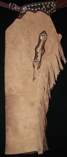 a brown suede purse with fringes hanging from it's side on a black background