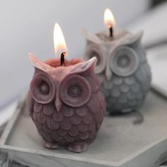 an owl candle holder with two candles in it