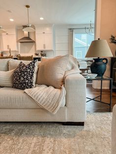 a living room filled with furniture next to a kitchen