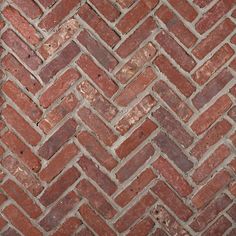 an old brick wall that has been made into a herringbone pattern in red and brown