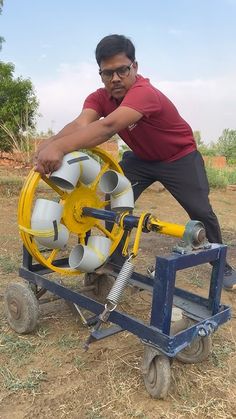 a man standing next to a yellow and white fire extinguisher on wheels