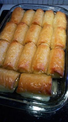 several trays of bread sitting on top of a stovetop next to each other