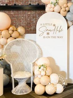 balloons and decorations are on display in front of a sign that says, a little snowflake is on the way