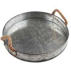 an old metal tray with rope on the handles and bottom is isolated against a white background