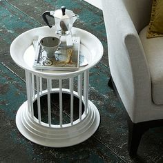 a white table sitting on top of a wooden floor next to a couch and chair