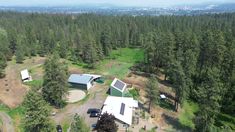 an aerial view of a house in the middle of a forest with lots of trees