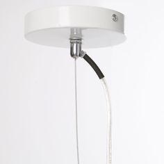 a white ceiling light with a black cord attached to the lamp fixture and two wires running through it