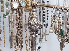 an assortment of necklaces and watches hanging on a wall