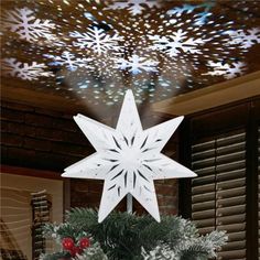 a christmas tree topper with snowflakes hanging from it's centerpiece