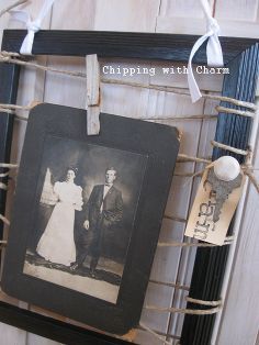 an old photo hanging on a rope with two clothes pins attached to it and a couple standing next to each other