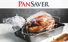 a turkey wrapped in plastic sitting on top of a metal pan next to a cutting board