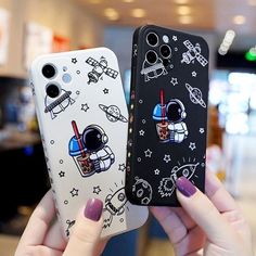 two people holding up cell phones with space themed designs on them, one is black and the other is white