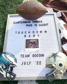 two football helmets and a sign on the grass with words written on it that read, quarterback throws pass is caught touch down baby team goodin july 22