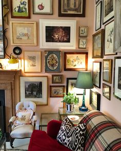 a living room filled with lots of framed pictures on the wall next to a fire place