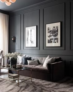 a living room filled with furniture and pictures on the wall above it's coffee table