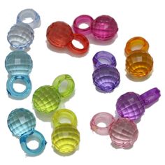 several different colored plastic rings on a white surface