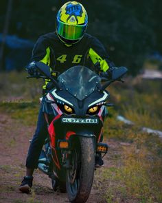 a man riding on the back of a motorcycle down a dirt road