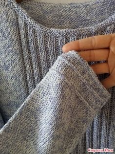 a person is holding their hand in the pocket of a sweater