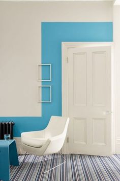 a white chair sitting in front of a blue and white wall next to a radiator