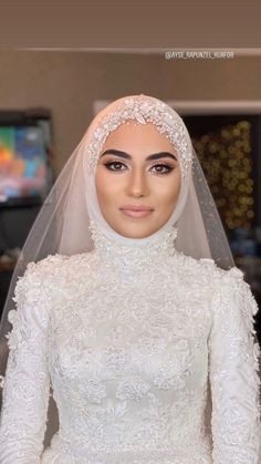 a woman wearing a white wedding dress with a veil on her head and an intricately designed gown