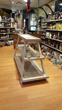 a store filled with lots of bottles and shelves full of liquor on wooden flooring