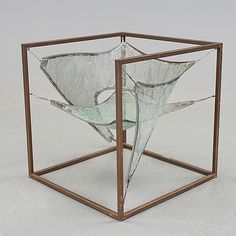 a glass sculpture sitting inside of a metal box