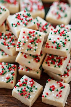 several square pieces of cake with sprinkles on them sitting on a table