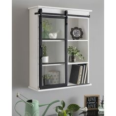 a white bookcase with glass doors and black trimmings on the bottom shelf