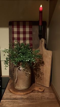 a potted plant sitting on top of a wooden table next to a cutting board