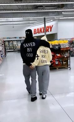 a man in a black hoodie is walking down the aisle with his back to the camera