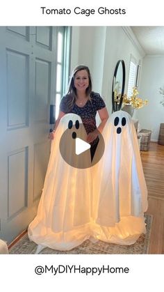 a woman standing in front of two ghost decorations