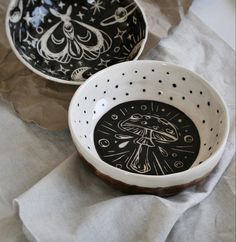 two black and white bowls with designs on them